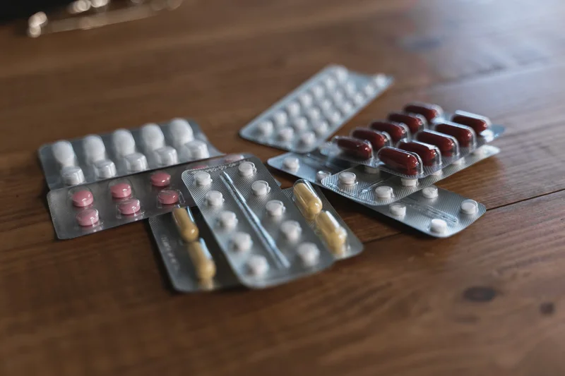 Strips of tablets and capsules on a wooden table