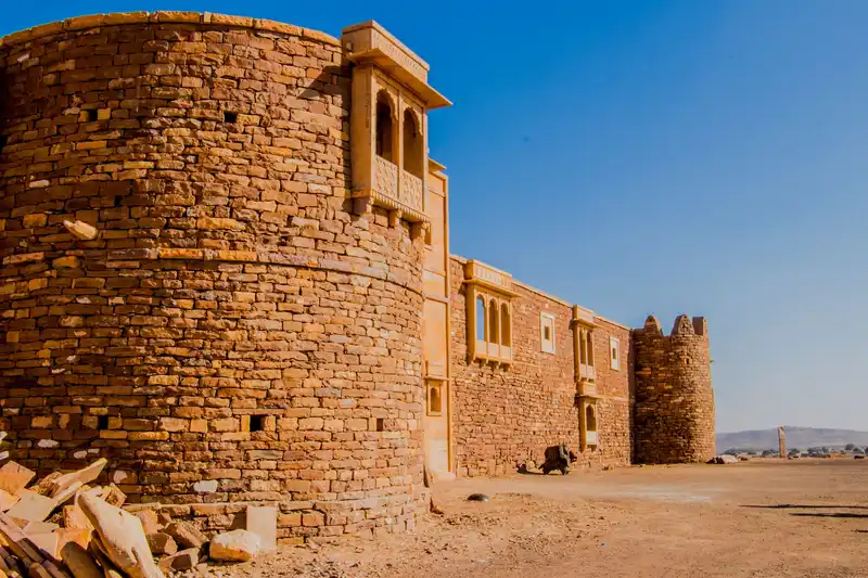 A sandstone fort wall under a clear blue sky
